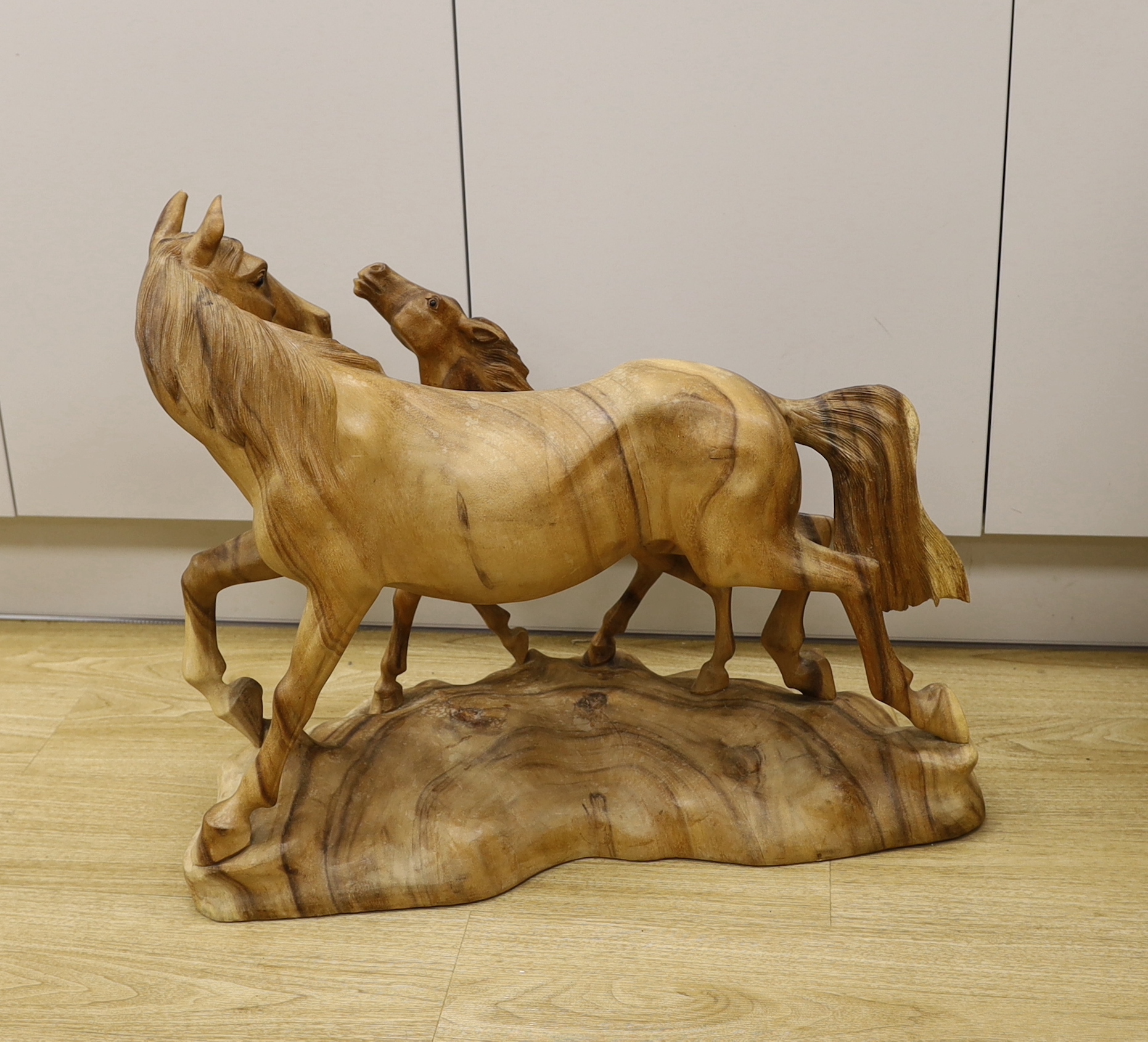 A large wooden carving of a horse and foal, 70cm wide